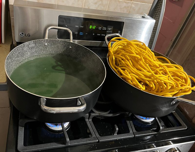 Large pot with a green dye bath and another large pot with dyed yellow nylon rope for shibari